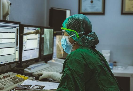 Profissional de saúde trabalhando com tecnologia médica e monitores